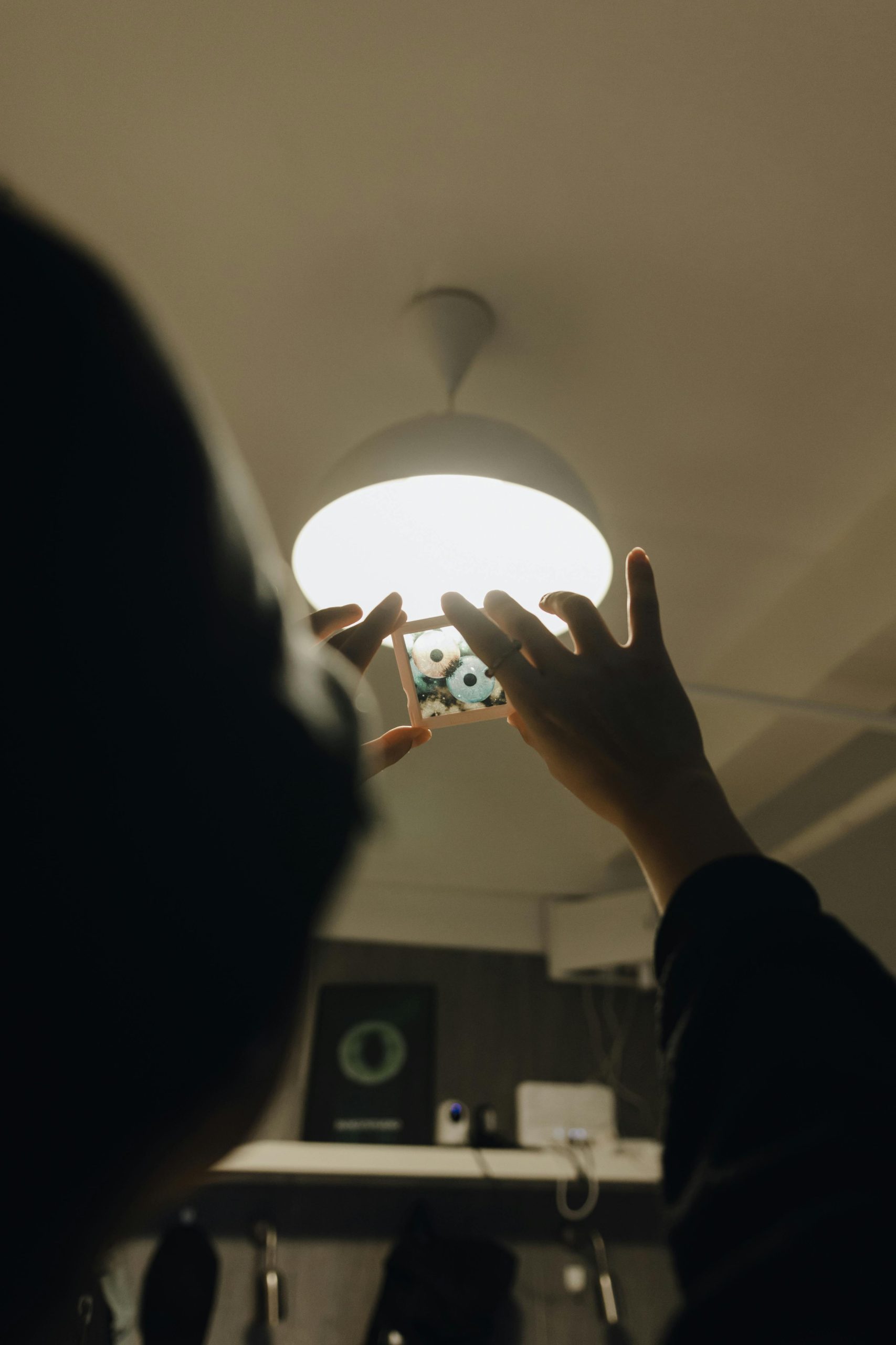 Close-up of hands adjusting a light fixture indoors, creating a home improvement scene.